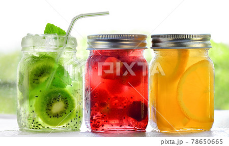 Bright Colorful refreshing summer drinks in glass jars with ice on white background 78650665