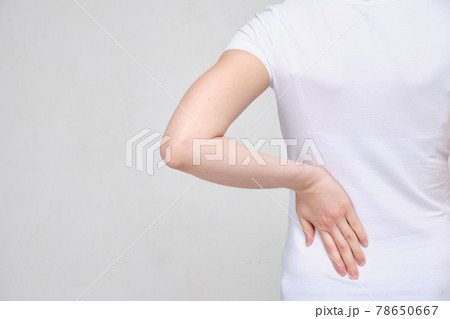 A girl in a white T-shirt suffers from pain in the side of the lower back. Sciatica concept. 78650667