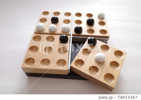 白と黒のビー玉を木製のトレイに並べていくボードゲーム 78653367
