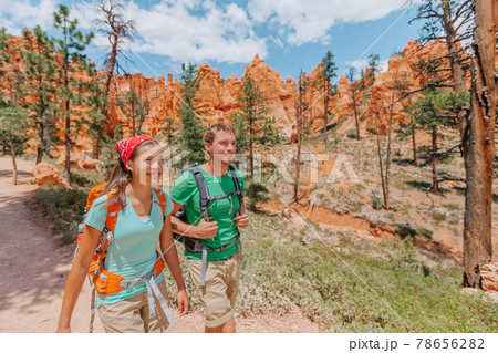 Hiking couple hikers walking smiling happy in summer mountain nature. Interracial couple Asian woman and Caucasian man in Bryce Canyon National Park landscape, Utah, United States Hiking couple hikers walking smiling happy in summer mountain nature. Interracial couple Asian woman and Caucasian man in Bryce Canyon National Park landscape, Utah, United States 78656282