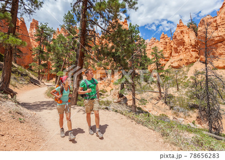 People hiking - couple hikers in Bryce Canyon walking on trail happy with backpacks. Multiracial young Asian woman and Caucasian man in Bryce Canyon National Park landscape, Utah, United States People hiking - couple hikers in Bryce Canyon walking on trail happy with backpacks. Multiracial young Asian woman and Caucasian man in Bryce Canyon National Park landscape, Utah, United States 78656283