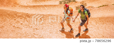 Hiking hikers tourists on summer trail trekking on mountain path with backpacks wearing hiking boots. Panoramic banner of active lifestyle couple traveling outdoor Hiking hikers tourists on summer trail trekking on mountain path with backpacks wearing hiking boots. Panoramic banner of active lifestyle couple traveling outdoor 78656296