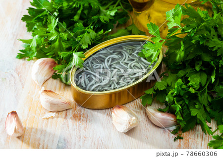 Pickled angoulas in tin can with garlic and parsley 78660306