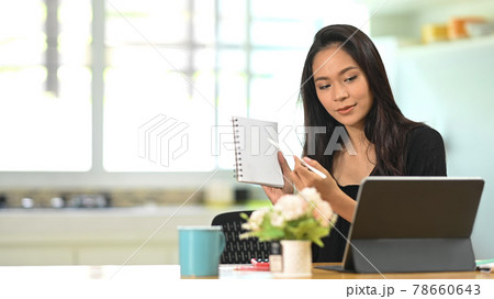 Young Asian businesswoman conference of colleagues through a tablet. Young Asian businesswoman conference of colleagues through a tablet. 78660643