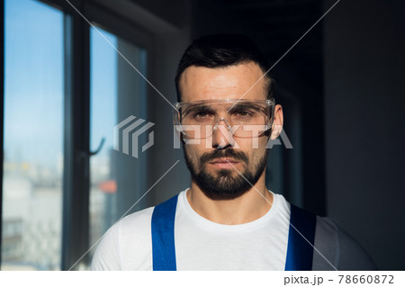 Close up, bearded worker wearing protective glasses Close up, bearded worker wearing protective glasses 78660872