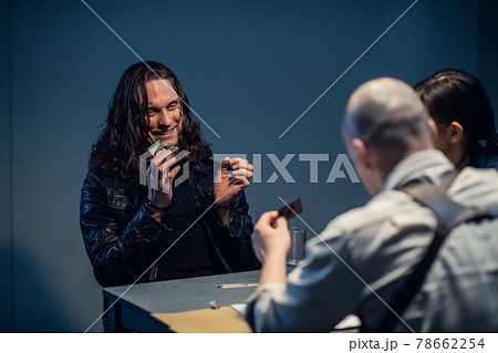 Interrogation of a homicidal maniac in the interrogation room. A police detective sits at a table with a suspect. 78662254