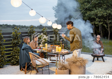 Friends dining at the backyard in the evening 78662454