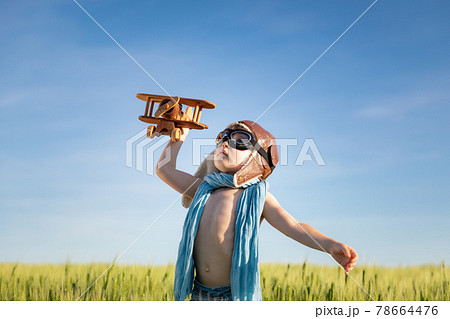 Happy child with airplane playing outdoor in summer 78664476