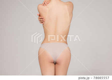 The beautiful woman's body isolated on gray background. Back view 78665557