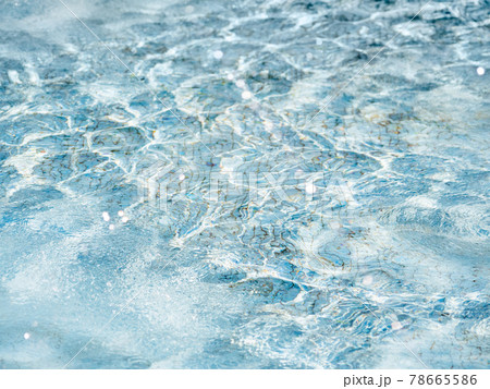 Sun beams on surface of water in swimming pool or fountain with blue mosaic bottom. Abstract background with wavy pattern of clear transparent water. 78665586