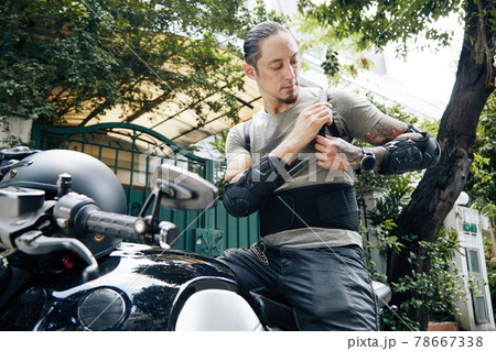 Motorcyclist Putting On Riding Gear Motorcyclist Putting On Riding Gear 78667338