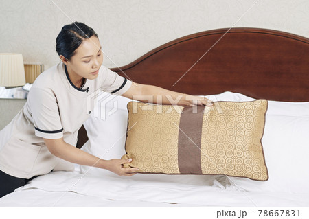 Maid Decorating Bed With Throw Pillows 78667831