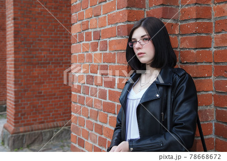 young girl stands near the wall of a gothic church 78668672