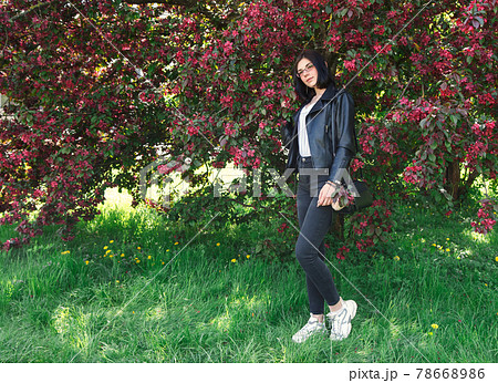 portrait of a young girl standing near cherry blossoms in spring 78668986