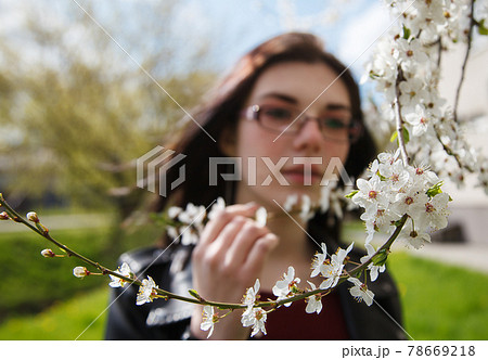 portrait of a young girl standing near cherry blossoms in spring portrait of a young girl standing near cherry blossoms in spring 78669218