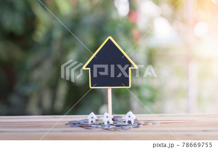 House signs and model houses are placed on coins. indicating the growth of the savings business to buy a house. House signs and model houses are placed on coins. indicating the growth of the savings business to buy a house. 78669755