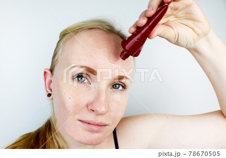 A young woman puts a gel mask on her face. Care for oily, problem skin A young woman puts a gel mask on her face. Care for oily, problem skin 78670505