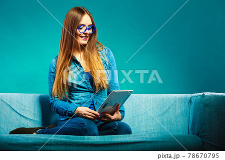 woman with tablet sitting on couch blue color 78670795