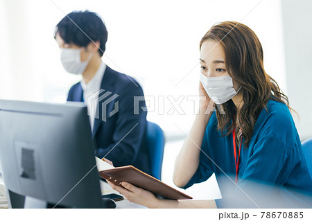 オフィスでマスクを着用して働くビジネスパーソン 78670885