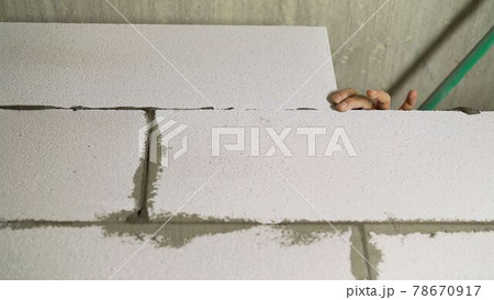 Construction of a cinder block wall. Block installation and erection of a wall from a white block. 78670917