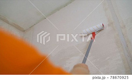 Wall paint roller. Roller Brush Painting, Worker painting on roller brush for protection Wall paint roller. Roller Brush Painting, Worker painting on roller brush for protection 78670925