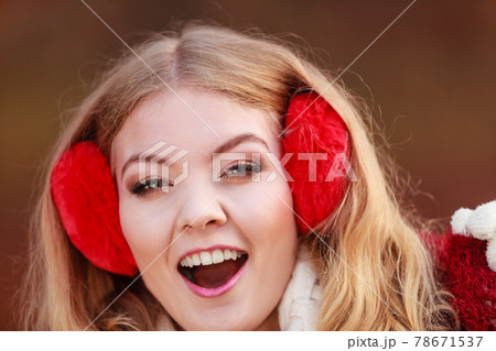 Portrait of pretty smiling woman in red earmuffs. Portrait of pretty smiling woman in red earmuffs. 78671537