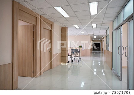 Empty hospital corridor with various rooms and trolley patient service 78671703