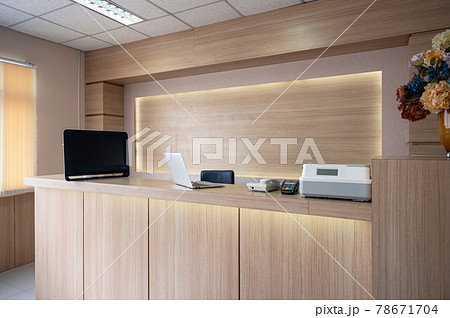 Modern wooden reception counter with monitor, laptop and electronic device in hospital 78671704