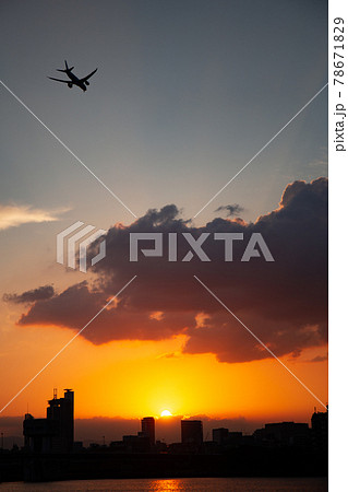 夕陽に染まる空に飛ぶ飛行機 78671829