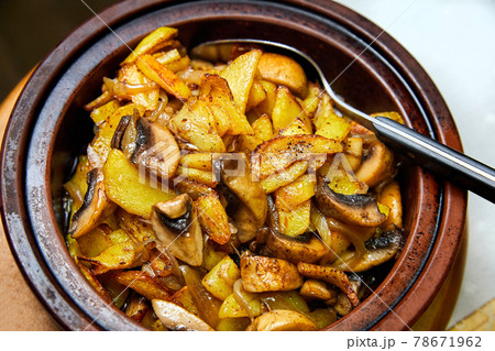 Potatoes with mushrooms baked in a pot. Close-up, selective focus 78671962