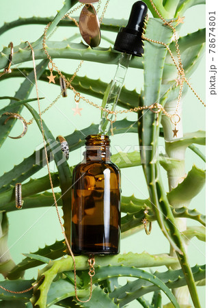 Concept is natural cosmetics. Serum with aloe extract. Plant with gold jewelry and serum Concept is natural cosmetics. Serum with aloe extract. Plant with gold jewelry and serum 78674801