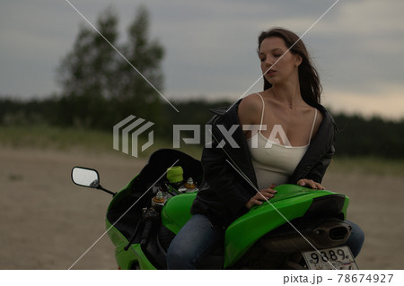 Cool woman in helmet on motorbike on beach 78674927