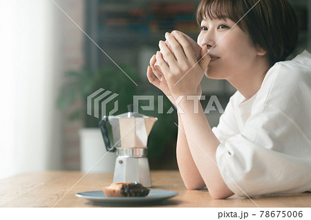 リビングでコーヒーを飲む若い女性 リビングでコーヒーを飲む若い女性 78675006