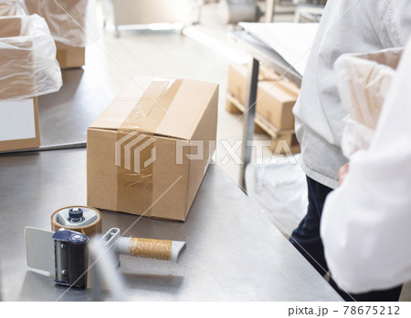 Worker packs cardboard boxes with finished goods at the factory, industry, manufacturing Worker packs cardboard boxes with finished goods at the factory, industry, manufacturing 78675212