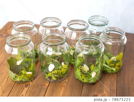 Jars with spices, garlic and pickle for preserving cucumbers. Jars with spices on a wooden background, preservation for the winter Jars with spices, garlic and pickle for preserving cucumbers. Jars with spices on a wooden background, preservation for the winter 78675225