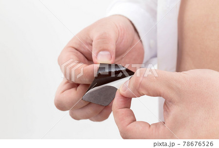 A man opens an anti-smoking plaster in his hands, close-up. Nicotine addiction, protection 78676526