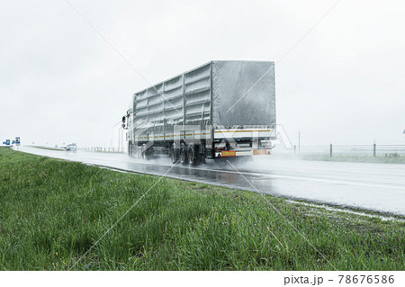 The movement of trucks of trucks with a semi-trailer and cars on a wet road in rain and fog and in poor visibility. Road safety concept. Copy space for text The movement of trucks of trucks with a semi-trailer and cars on a wet road in rain and fog and in poor visibility. Road safety concept. Copy space for text 78676586