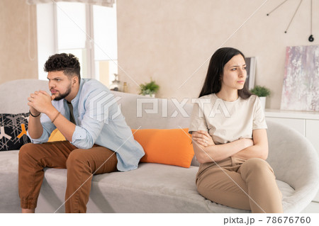 Upset husband and wife sitting on couch Upset husband and wife sitting on couch 78676760