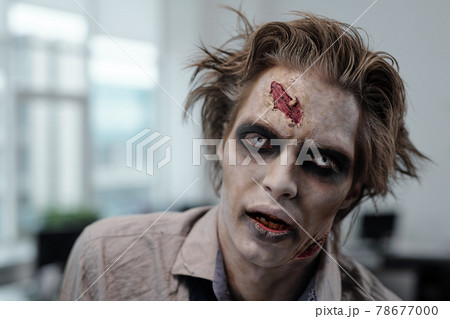 Male zombie with stage makeup on face Male zombie with stage makeup on face 78677000