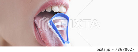 Young woman cleaning her tongue with scraper closeup 78678027