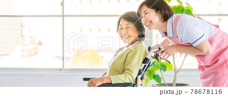 車いすを押す介護スタッフとシニア女性 78678116