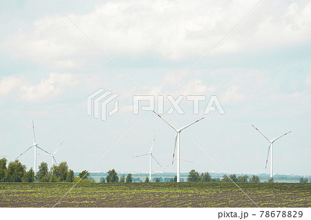 many windmills stand on a large field 78678829