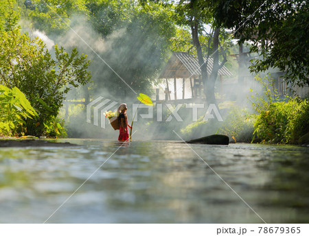 Karen tribe old woman with traditional dress carrying flowers basket walking on stream lake with green jungle forest. Nature landscape. People lifestyle. Karen tribe old woman with traditional dress carrying flowers basket walking on stream lake with green jungle forest. Nature landscape. People lifestyle. 78679365