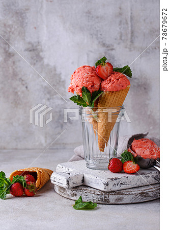 Strawberry ice cream in waffle cone. 78679672