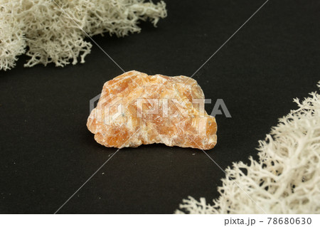 Orange Calcite from Brazil. Natural mineral stone on black background. Mineralogy, geology, magic of stones, semi-precious stones and samples of minerals. Close-up macro photo. Orange Calcite from Brazil. Natural mineral stone on black background. Mineralogy, geology, magic of stones, semi-precious stones and samples of minerals. Close-up macro photo. 78680630