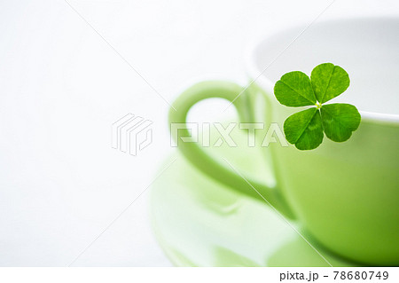 四つ葉のクローバーとコーヒーカップ 白背景素材の写真素材