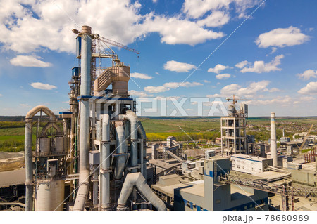Aerial view of cement factory with high concrete structure and tower crane at industrial production area. Manufacture and global industry concept. Aerial view of cement factory with high concrete structure and tower crane at industrial production area. Manufacture and global industry concept. 78680989