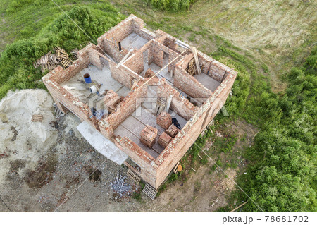Aerial view of building site for future house, brick basement floor and stacks of brick for construction. 78681702