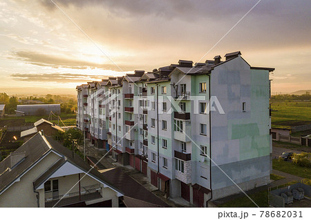 Top view of developing city landscape. Apartment building and suburb house roofs on pink sky at sunrise background. Drone photography. Top view of developing city landscape. Apartment building and suburb house roofs on pink sky at sunrise background. Drone photography. 78682031