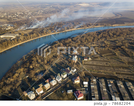 Aerial top view of river flowing through town. Rural landscape of residential houses, roads and trees on spring or autumn day. Drone photography. Aerial top view of river flowing through town. Rural landscape of residential houses, roads and trees on spring or autumn day. Drone photography. 78682204